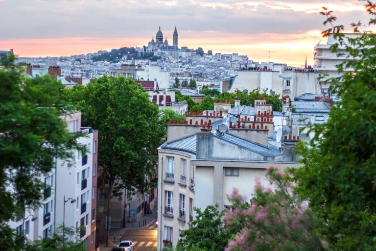 vue panoramique de Montmartre et du Sacré-Cœur depuis une rue verdoyante au crépuscule à Paris