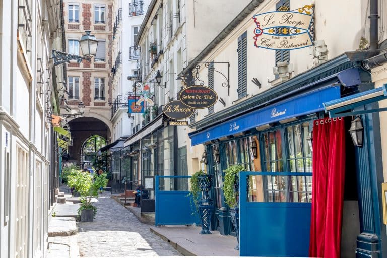 ruelle pavée avec restaurants traditionnels et enseignes vintage à Paris