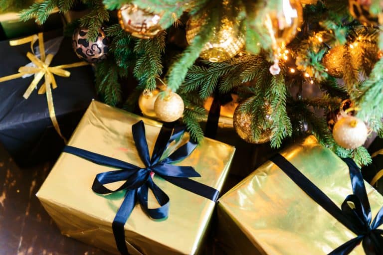 cadeaux de Noël emballés sous un sapin illuminé et décoré