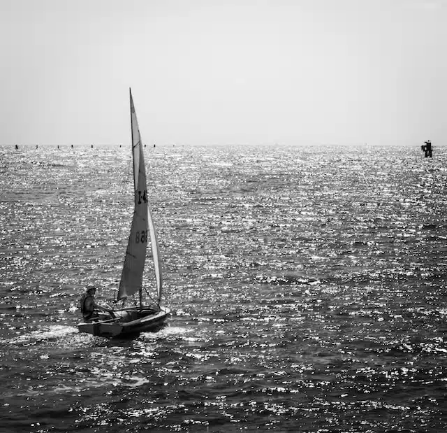voilier en navigation sur une mer scintillante en noir et blanc