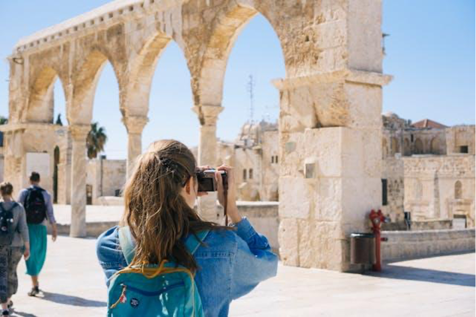 touriste photographiant les vestiges antiques d'un site archéologique méditerranéen