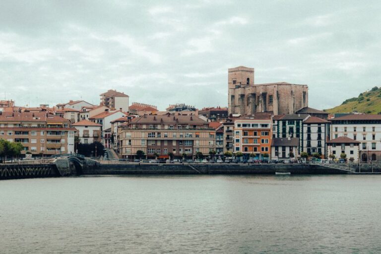 A picturesque view of the colorful buildings and church in Zumaia, Spain, along the coastline.
