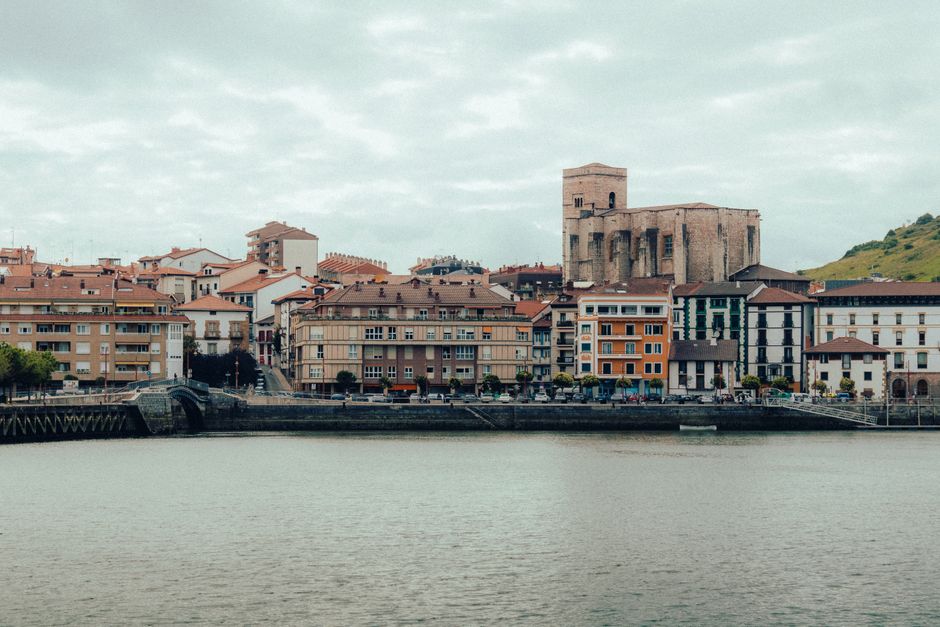 A picturesque view of the colorful buildings and church in Zumaia, Spain, along the coastline.