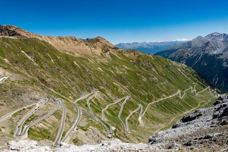 Breathtaking aerial view of the winding Stelvio Pass in the Alps on a sunny day.