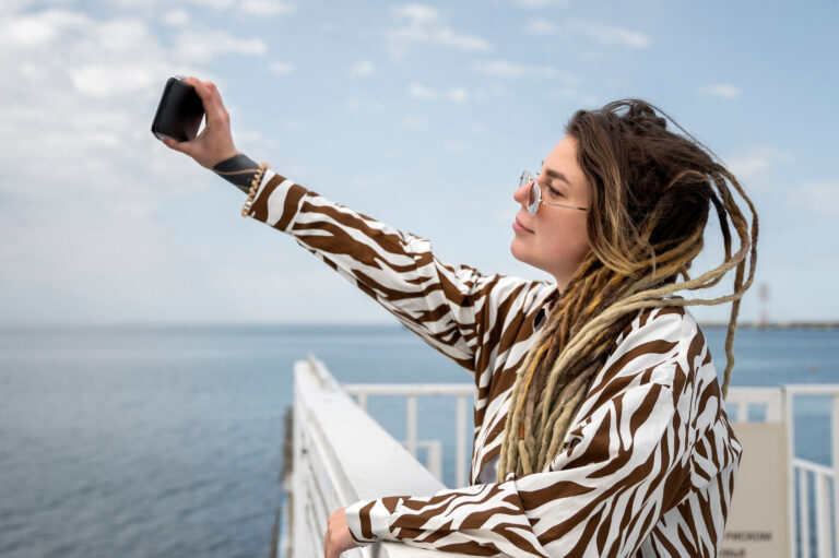 femme prenant un selfie en bateau avec vue sur la mer en arrière-plan