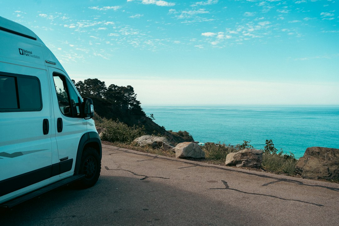 White camper van parked by the ocean road